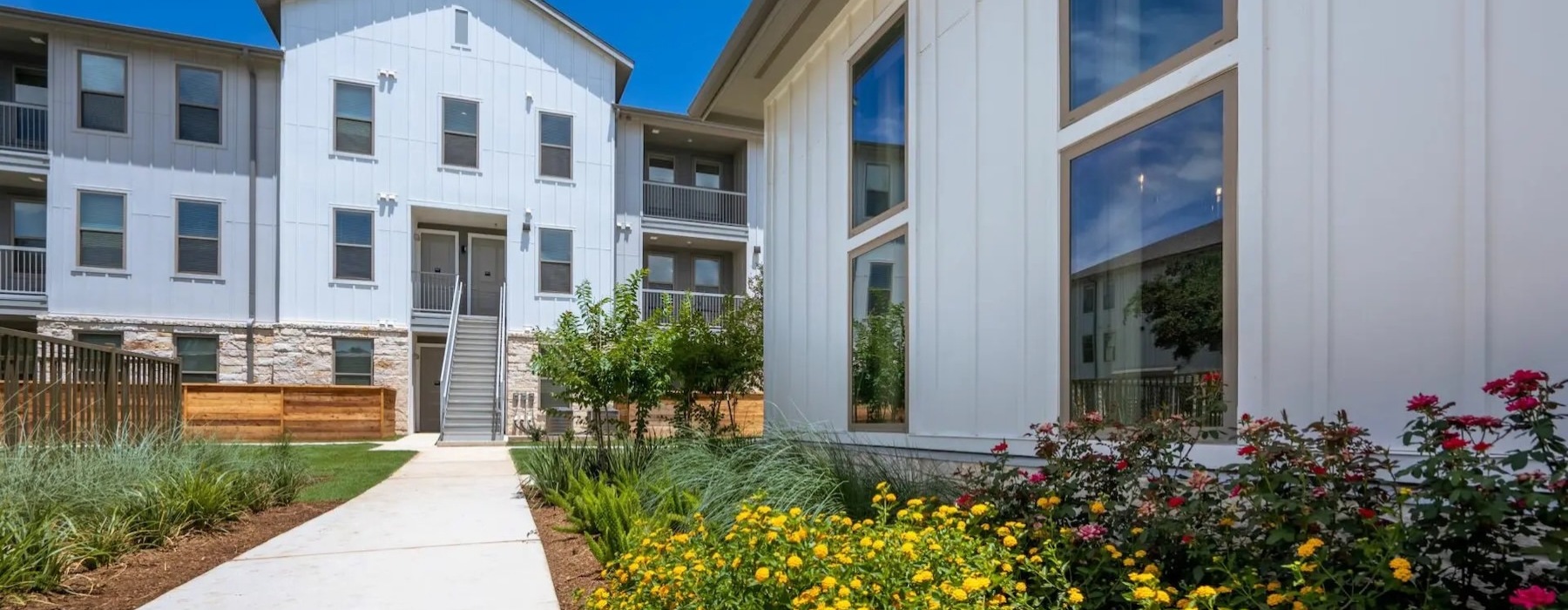 a building with a walkway and flowers