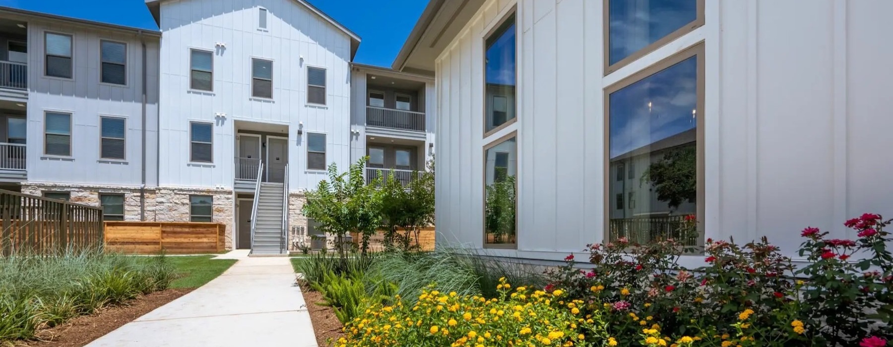 a building with a walkway and flowers